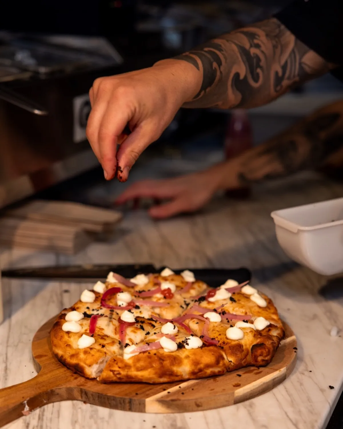 Pizzaiolo finishing a wood-fired pizza on the peel at Francesco Martucci