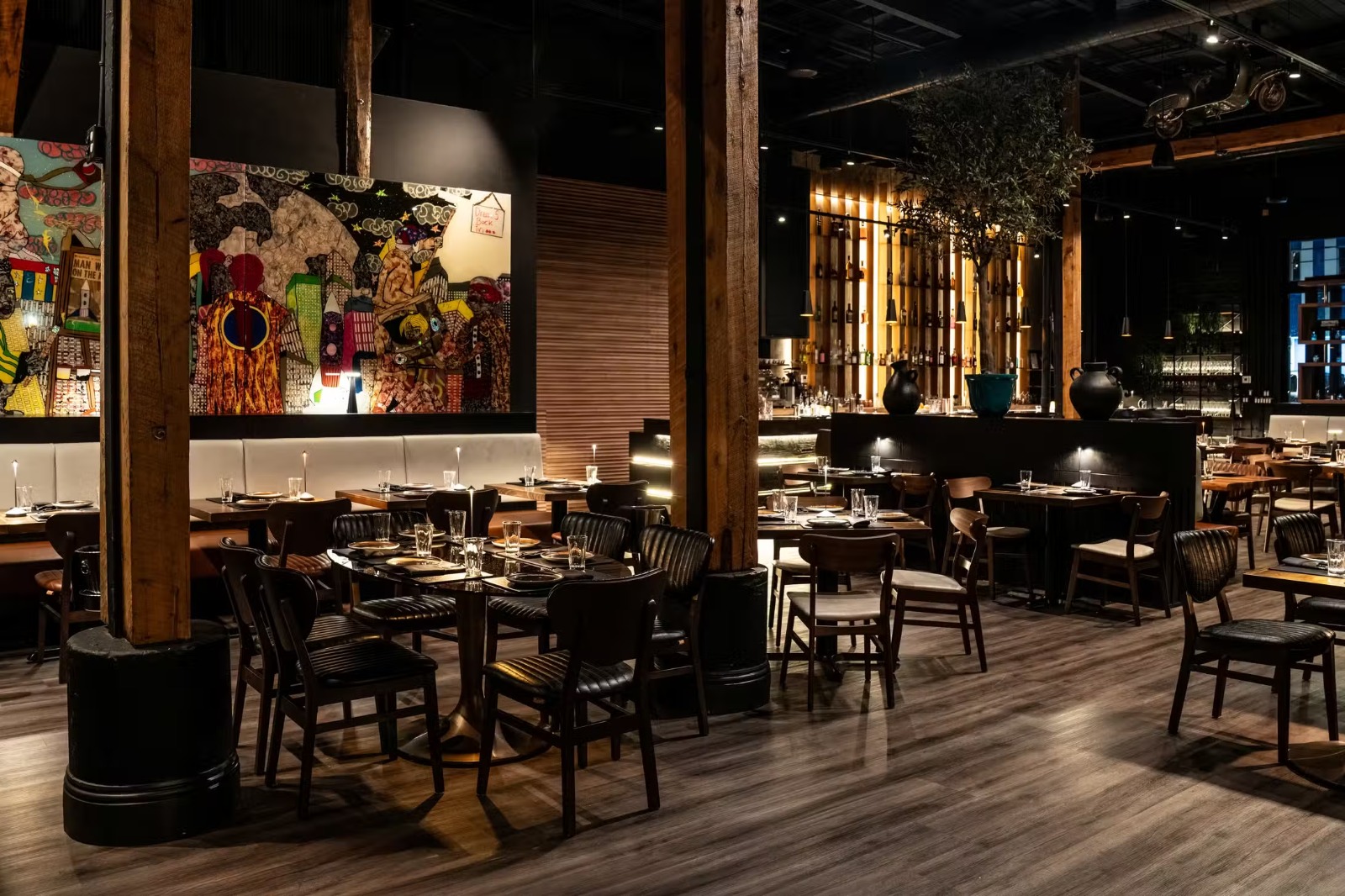 Dining room with colorful murals and timber columns at Francesco Martucci Wynwood